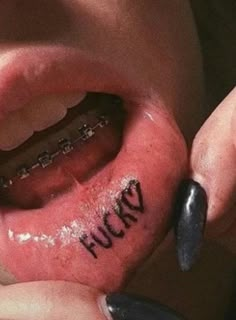 a person has their ear pierced with the word flud up written on it in black ink