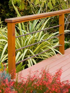 a wooden deck surrounded by plants and flowers