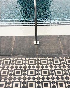 an artistic tiled floor next to a swimming pool