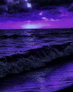 a purple sky over the ocean with waves