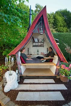 two people sitting in a small tent on the ground