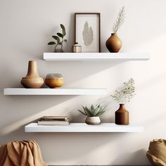 three white shelves with vases and plants on them