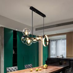 a dining room table and chairs with lights hanging from the ceiling