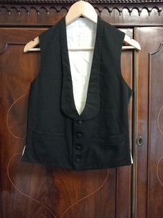 Old Genuine Vintage 1900s Suit Waistcoat Transport yourself back to the elegant days of the late 19th to early 20th centuries with this exquisite Victorian Edwardian waistcoat vest, believed to be from the 1900s to 1910s. With its timeless design and historical significance, this piece is a true vintage gem. This waistcoat features a four-button front, two welt pockets, and a distinctive shawl label, adding to its vintage charm. It's a piece of fashion history that reflects the style and sophist Elegant Daywear Vest With Buttons, Fitted Daywear Vest With Buttons, Fitted Vest With Buttons For Daywear, Vintage Formal Vest With Buttons, Fitted Vintage Vest With Buttons, Vintage Fitted Vest With Buttons, Black Elegant Vest For Costume, Elegant Black Vest For Costume, Sleeveless Buttoned Vest For Costume