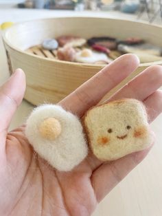 a hand holding a small piece of bread with a smiley face on it