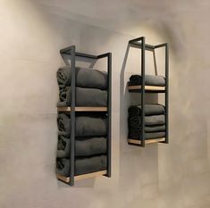 two metal shelves with towels hanging on them