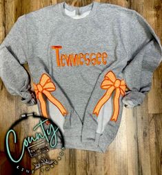 A sports team embroidered crewneck with side bows would be a stylish and feminine twist on traditional fanwear. Here's what such a design might include: Crewneck Style: *A classic, oversized crewneck sweatshirt in a soft and durable material like cotton and polyester  Embroidery: *The team's logo, mascot, or name elegantly embroidered on the front or chest area for a high-quality look. Side Bows: *The bows could match the team's colors or contrast for a bold statement. Color Options: *Available in team colors, neutral tones like white, black, or gray, with accent colors that pop. Fit & Style: *A relaxed, slightly oversized fit with a slightly cropped or full-length option to suit different preferences. Logo Mascot, Crewneck Style, Oversized Crewneck, Embroidered Crewneck, Neutral Tones, Accent Colors, Sports Team, Team Logo