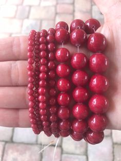 red beads are being held in someone's hand