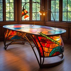 a stained glass desk in front of two windows