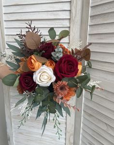 a bouquet of flowers sitting on top of a wooden door