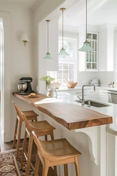 a kitchen with white walls and wooden stools