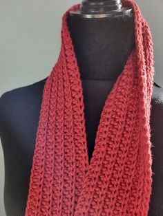 a red knitted scarf on top of a mannequin