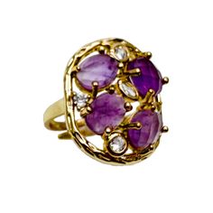 The setting of the ring is designed to accentuate the magnificence of the amethyst stones, allowing them to take center stage. Crafted with precision and attention to detail, the ring showcases the intricate beauty of the stones and enhances their natural radiance.  This statement ring is perfect for those who appreciate bold and distinctive jewelry. Its unique design and vibrant amethyst stones make it a standout piece that adds a touch of elegance and sophistication to any outfit. Amethyst is the birthstone for February. It is believed to have functions that include promoting clarity, intuition, spiritual growth, and emotional balance. Avoid wearing your gemstone jewelry when using cleaning agents or engaging in activities that involve exposure to chemicals. Yellow Gold Amethyst Ring With Gemstone Accents, Luxury Amethyst Rings With Gemstone Accents, Luxury Amethyst Gemstone Ring, Luxury Amethyst Ring Jewelry, Purple Gemstone Fusion Rings, Multi-stone Amethyst Ring In Yellow Gold, Purple Amethyst Cluster Ring With Gemstone, Purple Amethyst Rings With Gemstone Accents, Amethyst Open Ring With Accent Stones