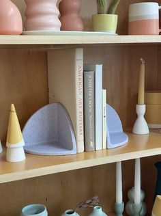 shelves with vases, candles and books on them in a home office area or playroom