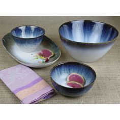 three bowls and two plates with designs on them, one has a pink flower in the center