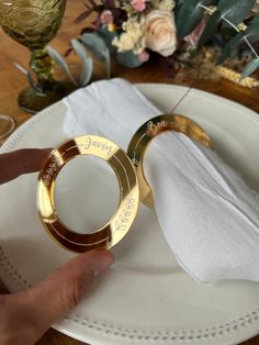 two gold wedding rings sitting on top of a white plate