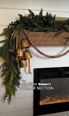 there is a christmas wreath hanging on the wall next to a fire place with bells