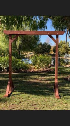 a wooden arbor in the middle of a park