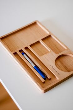 a wooden tray with a pen and pencil on it