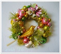 a christmas wreath with ornaments on it and a bird sitting on top of the wreath