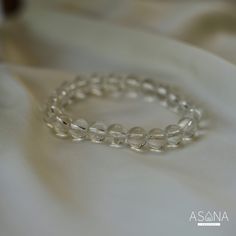 Introducing Asana Crystals' Clear Quartz Bracelet—a timeless and versatile accessory that embodies clarity, purity, and positive energy. Handcrafted from natural Clear Quartz, each bead in this bracelet exudes a pristine transparency symbolizing clarity of mind and spirit. Known as the "master healer," Clear Quartz amplifies energy, enhances intuition, and promotes overall well-being. Featuring smooth, round beads measuring 8mm, this bracelet offers a classic elegance suitable for any style or occasion. With no closure, the beaded stretch design ensures effortless wearability and comfort, allowing you to carry the uplifting energy of Clear Quartz throughout your day. Embrace the pure and transformative energy of Clear Quartz and elevate your look with Asana Crystals' Clear Quartz Bracelet— Minimalist Crystal Bracelet With Round Beads For Healing, Minimalist Round Beads Crystal Bracelet For Healing, Elegant Beaded Bracelets For Meditation, Adjustable Clear Round Bead Crystals, Elegant Crystal Bracelet With Gemstone Beads For Meditation, Everyday Hypoallergenic Crystal Bracelet With Round Beads, Elegant Crystal Bracelet For Meditation, Elegant Hand-strung Crystal Bracelet For Healing, Elegant Hand-strung Crystal Bracelet For Meditation