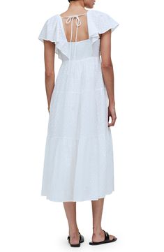 This ever-enchanting cotton maxi is designed with fluttering sleeves and a flouncy tiered skirt. 50" length (size 8) Adjustable back tie closure V-neck Short sleeves Lined 100% cotton Machine wash, tumble dry Imported Cotton Midi Dress With Ruffle Sleeves, Elegant Tiered Cotton Midi Dress, Feminine Tiered Cotton Midi Dress, White Flutter Sleeve Maxi Dress For Daywear, Flowy Tiered Cotton Dress With Ruffle Hem, Tiered Cotton Maxi Dress With Ruffle Hem, White Maxi Dress With Flutter Sleeve And Ruffle Hem, Cotton Maxi Dress With Ruffles For Daywear, Flowy Cotton Maxi Dress With Ruffles