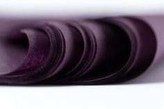 a close up of a purple tie on a white surface