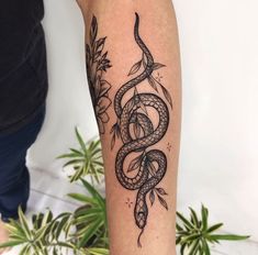 a black and white snake tattoo on the arm