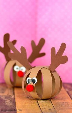 paper plate reindeers made out of construction paper and googly eyes on a wooden table