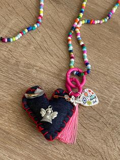 a heart shaped keychain with a tassel hanging from it