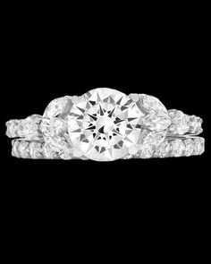 a diamond engagement ring set on top of a black background with the center stone surrounded by smaller diamonds