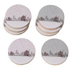 four white plates with houses and trees on them