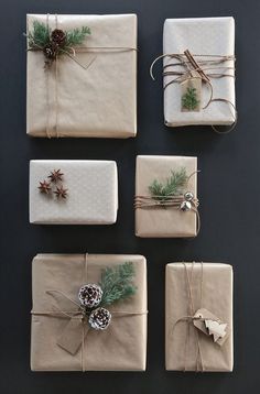 four wrapped presents tied with twine and pine cones