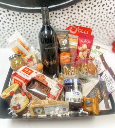 a bottle of wine sitting on top of a tray filled with food and condiments