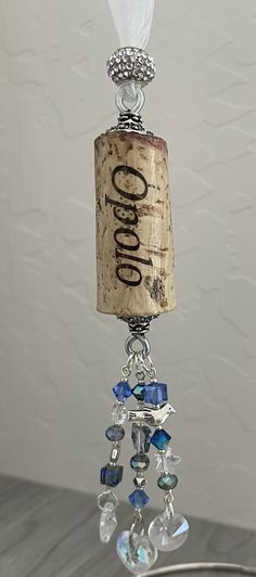 a wine bottle is hanging from a wire with glass beads and crystal bead accents