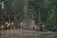 a person with an umbrella walking down a street in the rain