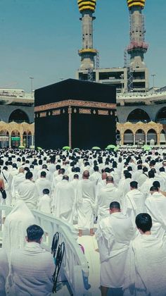 a large group of people sitting in front of a building with two towers on it