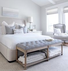 a bedroom with white walls, carpet and a chandelier hanging from the ceiling