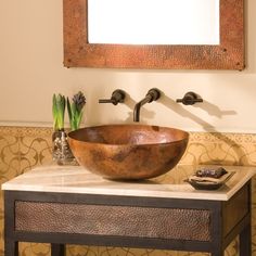 a bowl shaped sink sits on a marble countertop in front of a wall mounted painting