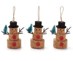 three snowmen made out of cork with red buttons on their heads and black hats