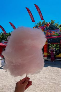 a cotton candy lollypop is being held in front of an amusement park ride