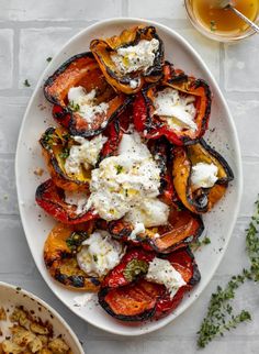 a white plate topped with roasted vegetables and feta cheese