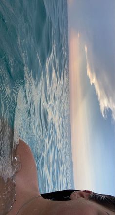 a person laying down in the water with their feet up