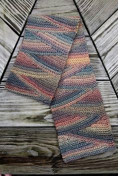 a knitted scarf sitting on top of a wooden floor