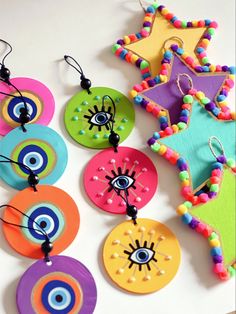 some colorful paper plates are hanging on the wall with beaded eyes and stars around them