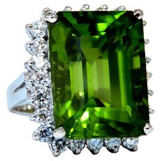 Emerald Cut Peridot Classic GIA Certified 18.53ct. Natural Peridot ring. Emerald cut, clean clarity & Transparent. Classic Green Color 17.03 X 13.00 X 10.45mm Report #2171291318 1.20ct Side natural round diamonds Full cut Brilliants G-color Vs-2 Clarity 14kt. white gold 11.1 grams. Ring is 20 x 17mm (Top Deck) Depth: 11mm current ring size: 5 We may resize, please inquire. $22,000 Appraisal Certificate to accompany Diamonds Rings, Ring Emerald Cut, Ring Emerald, Peridot Ring, Green Peridot, Solitaire Ring, Emerald Cut, Green Color, Green Colors