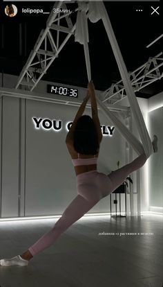 a woman is doing yoga in front of a large screen with the words you only on it