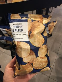 someone holding up a bag of potato chips