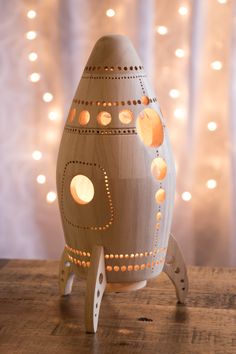 an egg shaped like a rocket ship on a wooden table with lights in the background