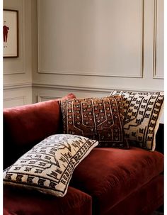 a red couch with two decorative pillows on it